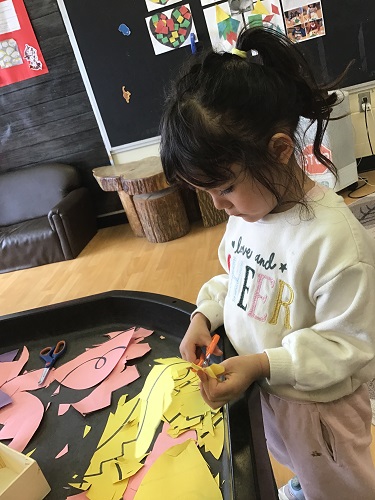Preschool child cutting shapes like egg designs
