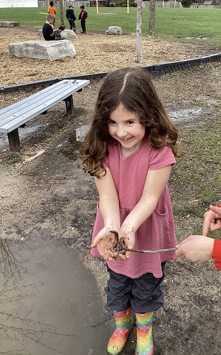 child showing off a handful of worms