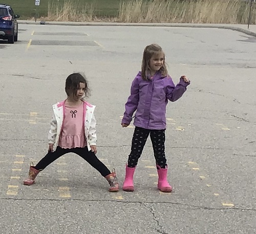 Children outside on the black top playing a body movement game