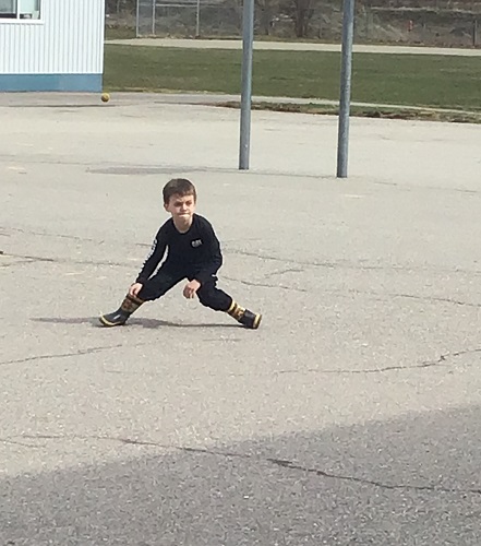 A child on the black top freezing in position during a game