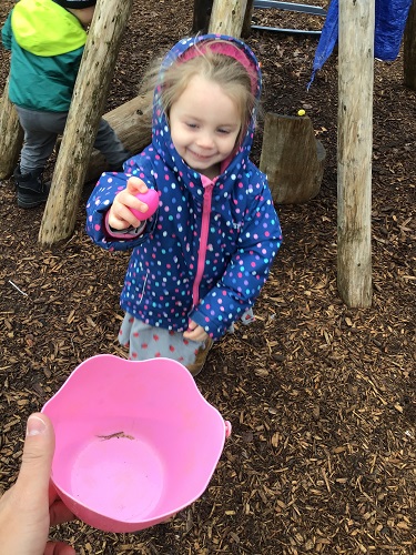A child putting eggs into the basket