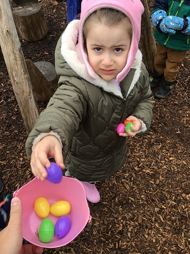 A child putting eggs into the basket