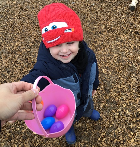 A child putting eggs into the basket