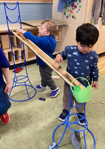 Children using plastic eggs to send down the ramps