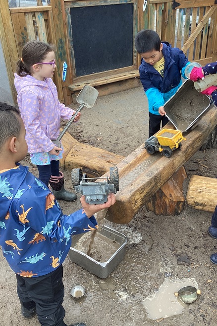 3 school age children exploring the water feature