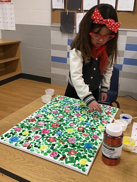A school age child painting on a canvas