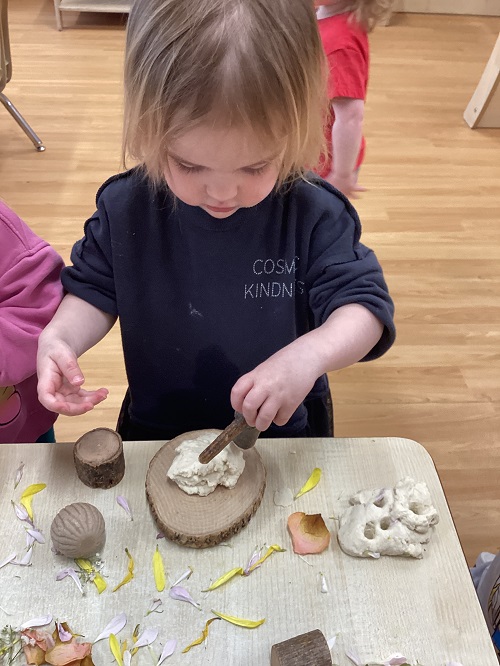 A toddler child exploring with natural materials