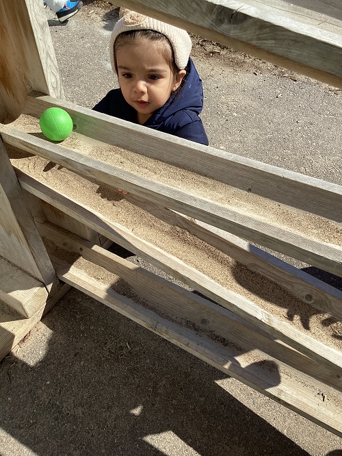 An infant child watching a ball go down the ball drop