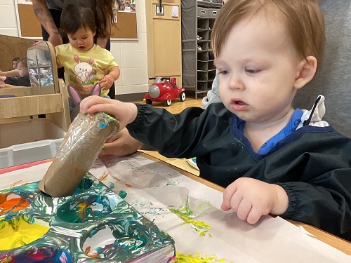 child in black painting with tube
