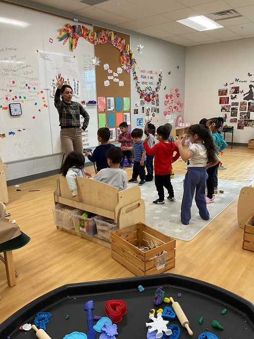 children and educator dancing