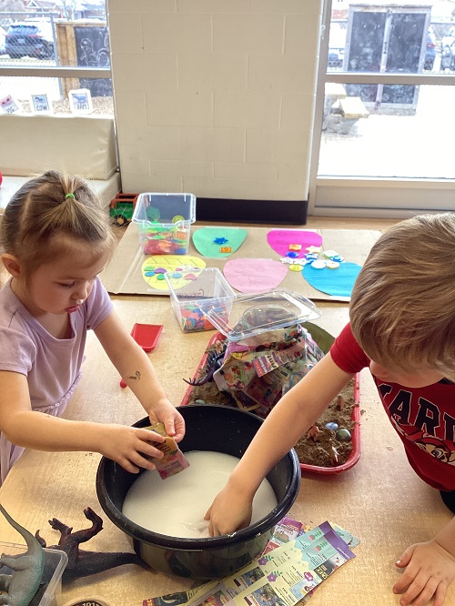 children mixing ingredients in a bowl to create a volcano