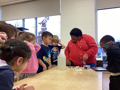 Kids around a table learning with and educator