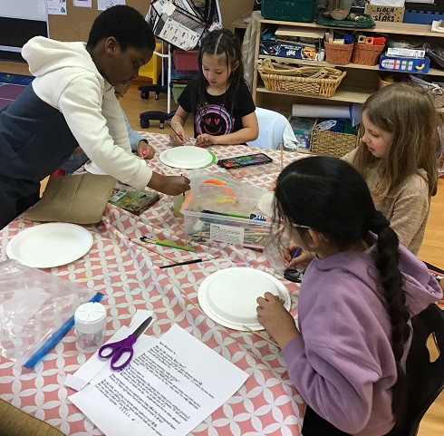 group of children doing some crafting at a table