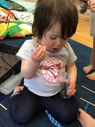 Chjild putting object in bottle