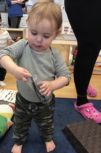 child putting object in bottle