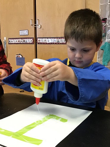 Boy using glue pouring it on paper