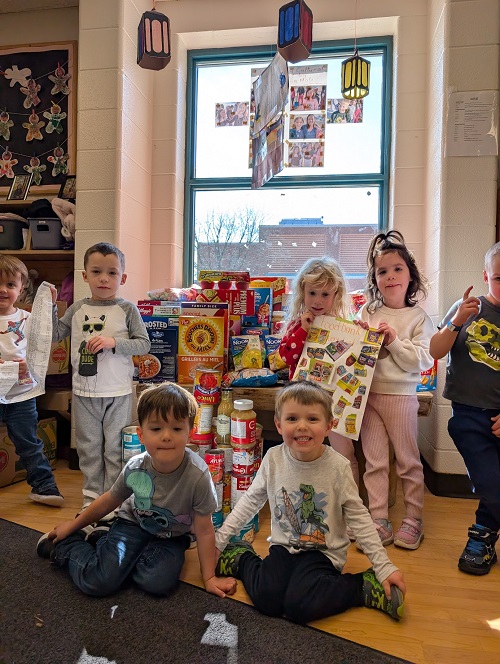 children standing in front of their collected food