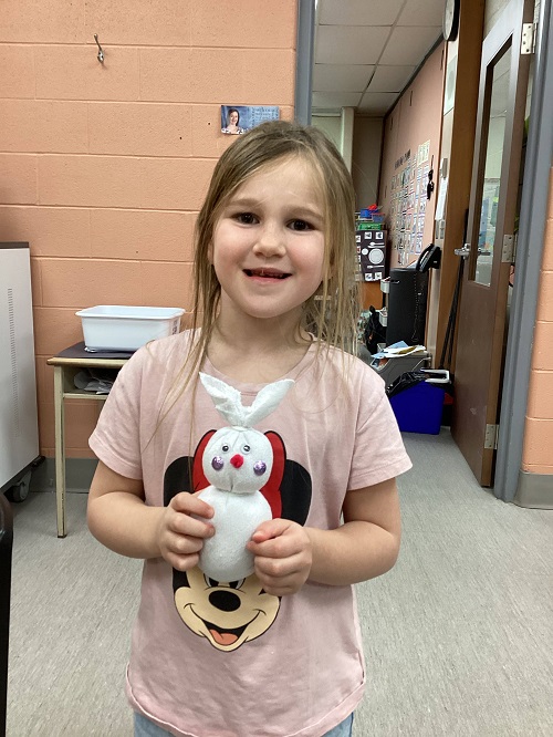 a child holding their finished bunny with pride