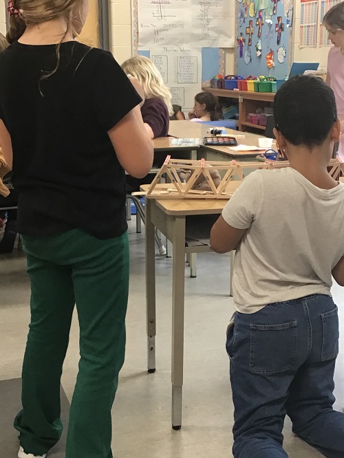 children placing their bridge onto a table