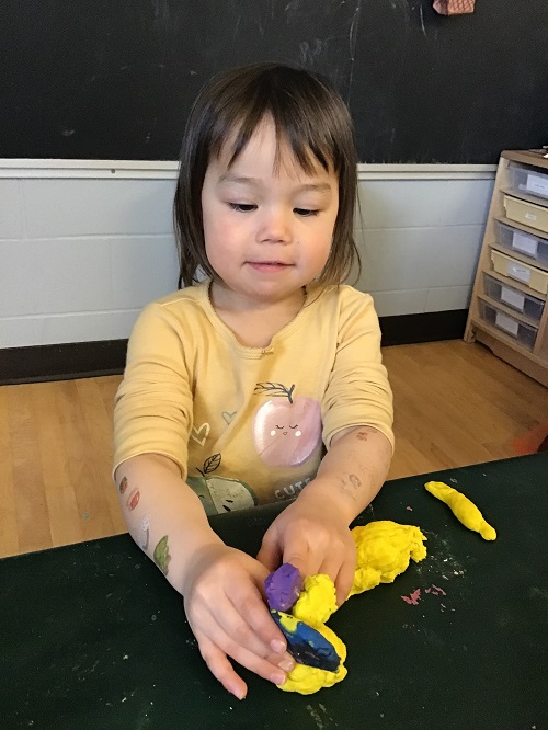 Child creating their playdough family.