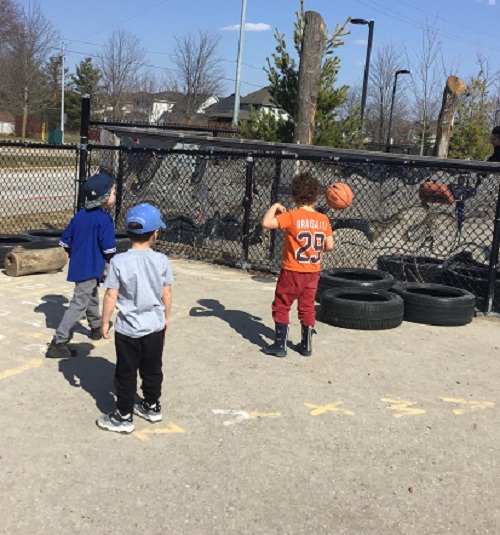 Children playing basketball, using the tires as the hoops.