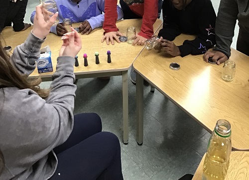 Adult showing the children food colouring.