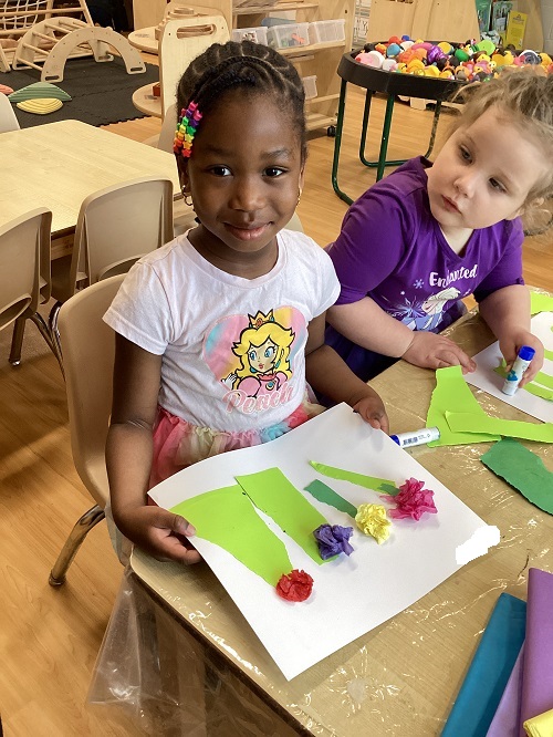 A preschool child showing off their spring inspired art work
