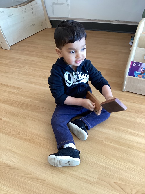 A toddler child exploring sand blocks