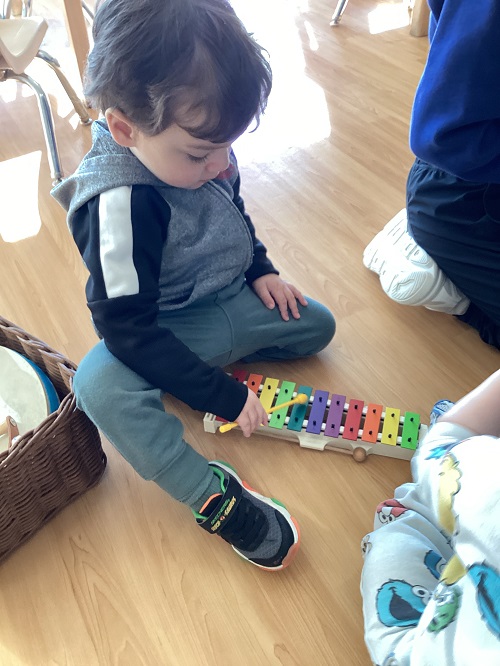 A toddler child exploring a xylophone